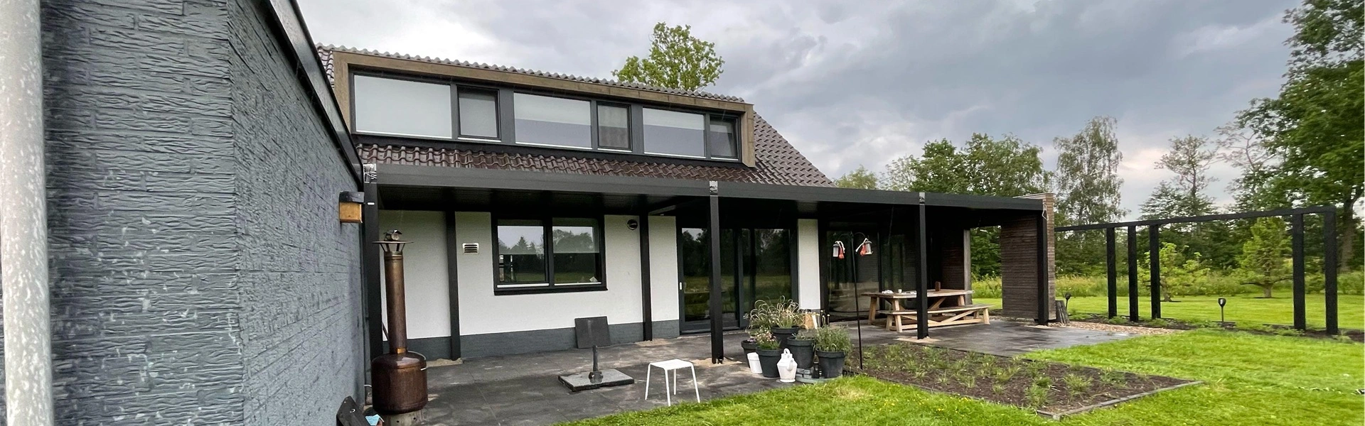 Lamellen overkapping Varia met tuintafel en open zicht op groene tuin