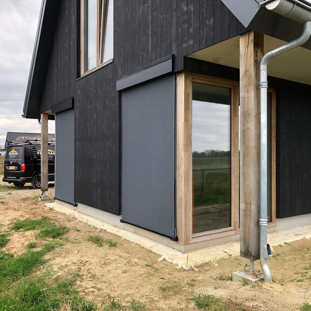 Landelijke woning met kabelscreens op zwarte gevel