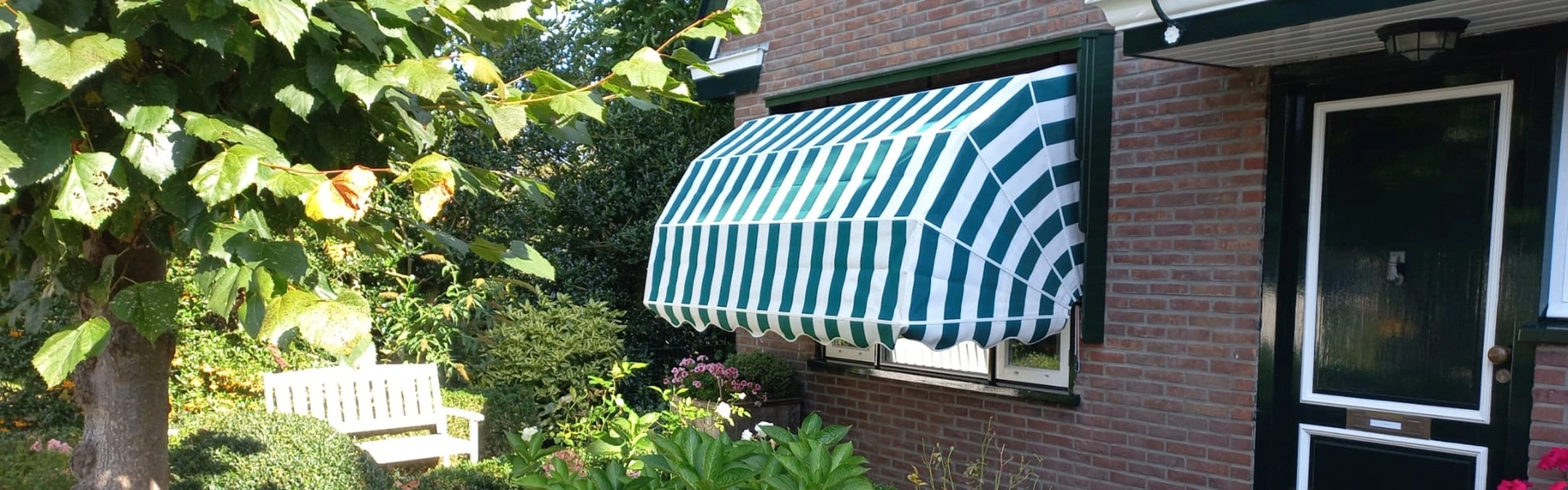 Markies in groen-wit gestreept doek naast een voordeur