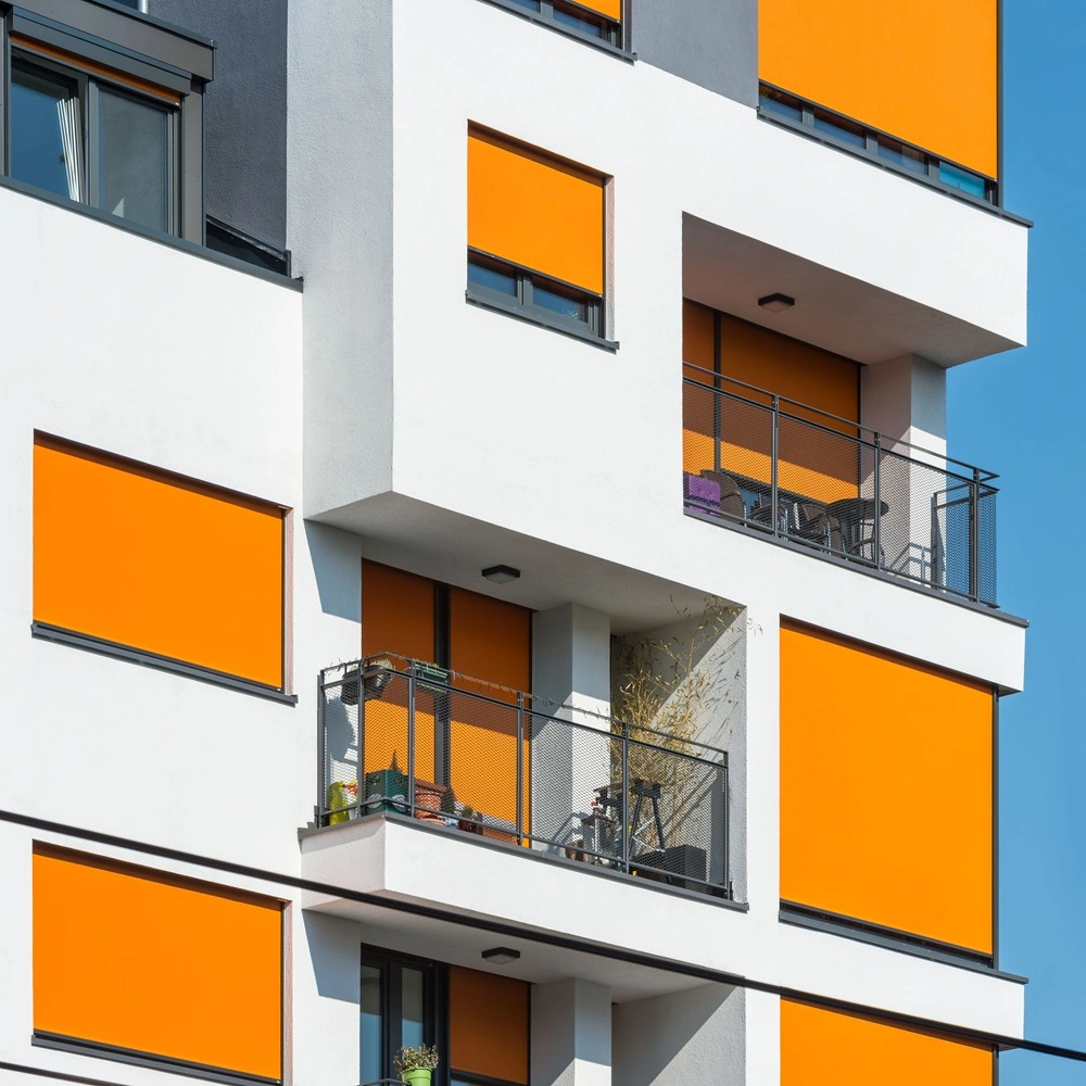 Oranje RolSCREEN2 zonwering op appartementencomplex met balkons