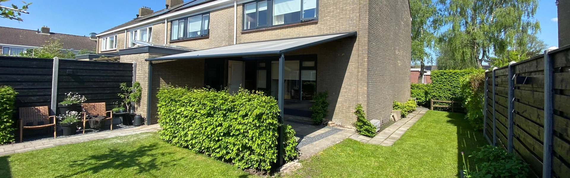 Project Veldman Zonwering textieloverkapping bij hoekwoning met groene tuin