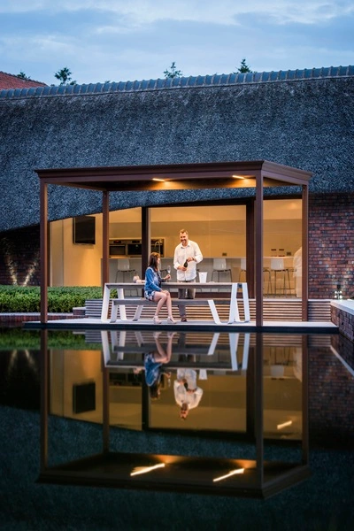 Renson Algarve lamellen overkapping bij een luxe woning met vijverreflectie Renson Algarve lamellen overkapping bij een luxe woning met vijverreflectie