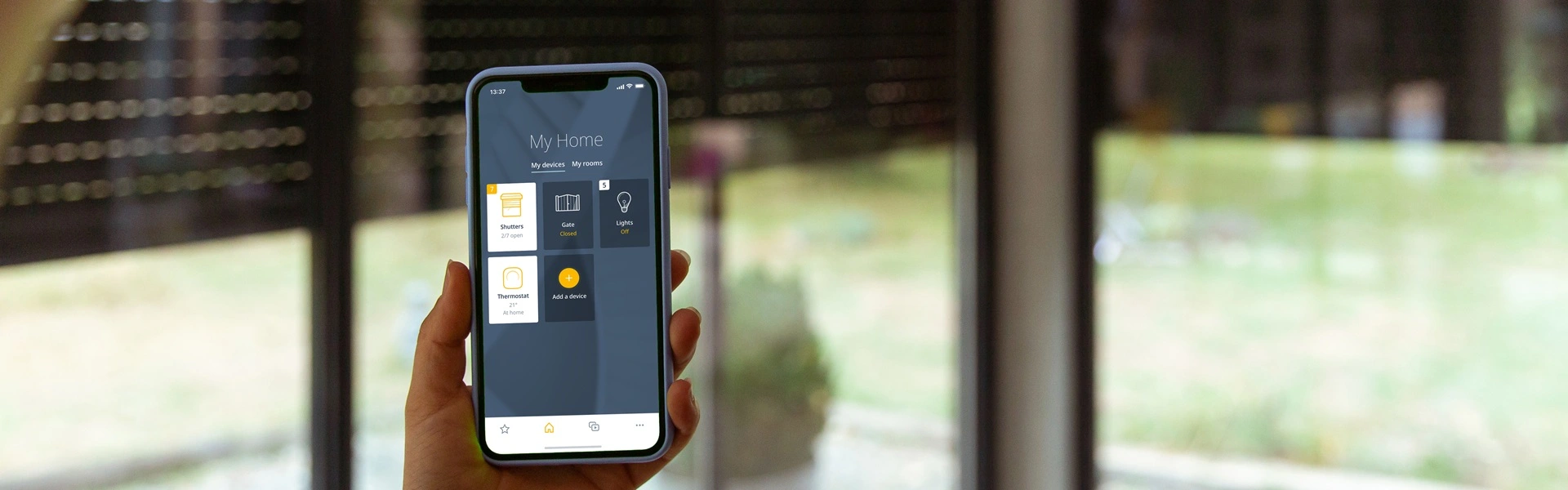 Smartphone toont Somfy TaHoma app met bediening van domotica-systemen
