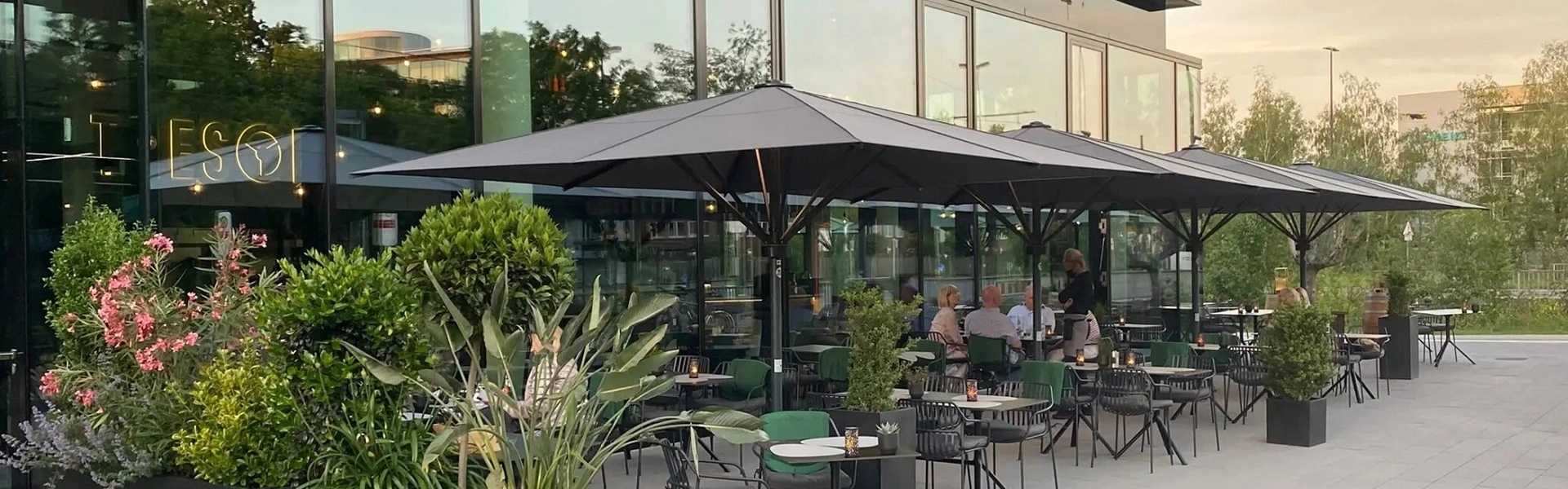 Terras met stijlvolle zwarte parasols bij een moderne horecagelegenheid
