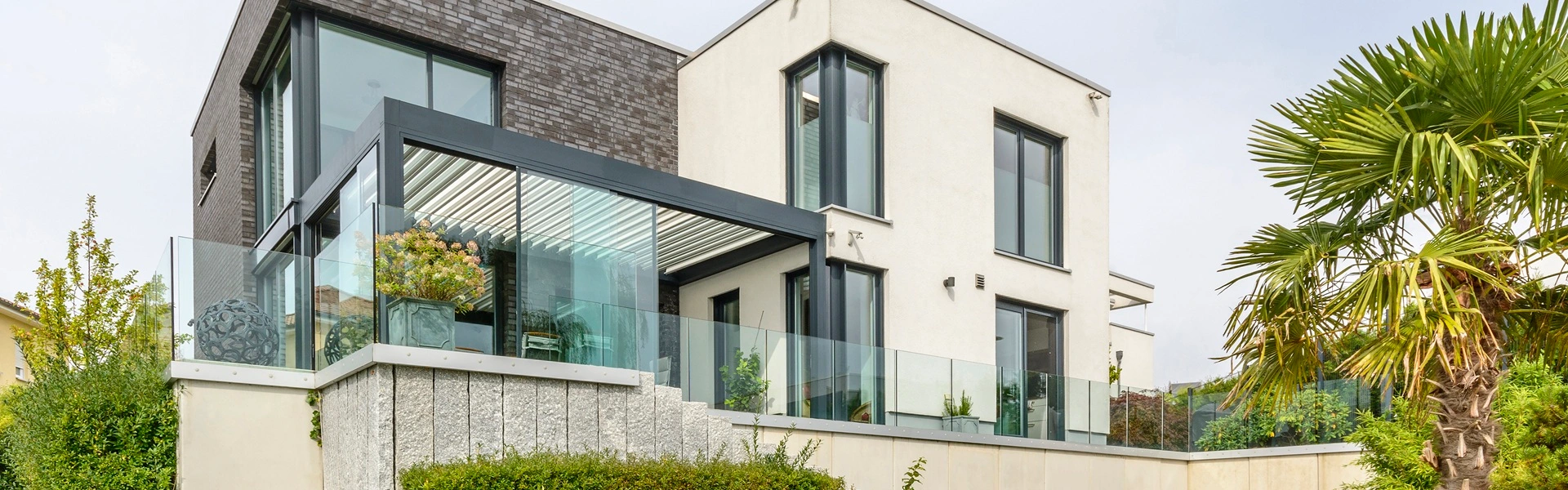 Terrasoverkapping Renson Camargue met lamellen en uitzicht op een moderne tuin