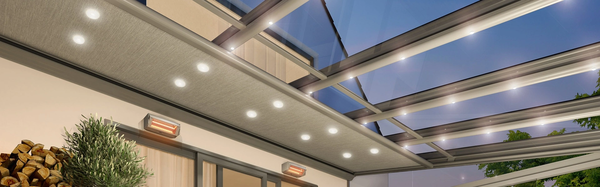 Verlichte Serre zonwering Sottezza in glazen overkapping bij avondlicht