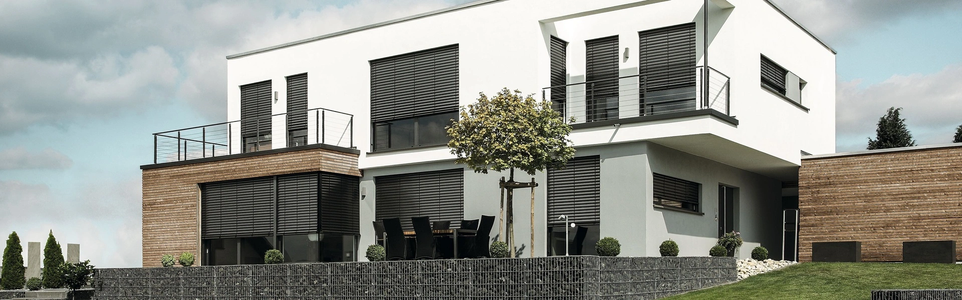 Witgepleisterde woning met buitenjaloezie raffstore voor zonwering