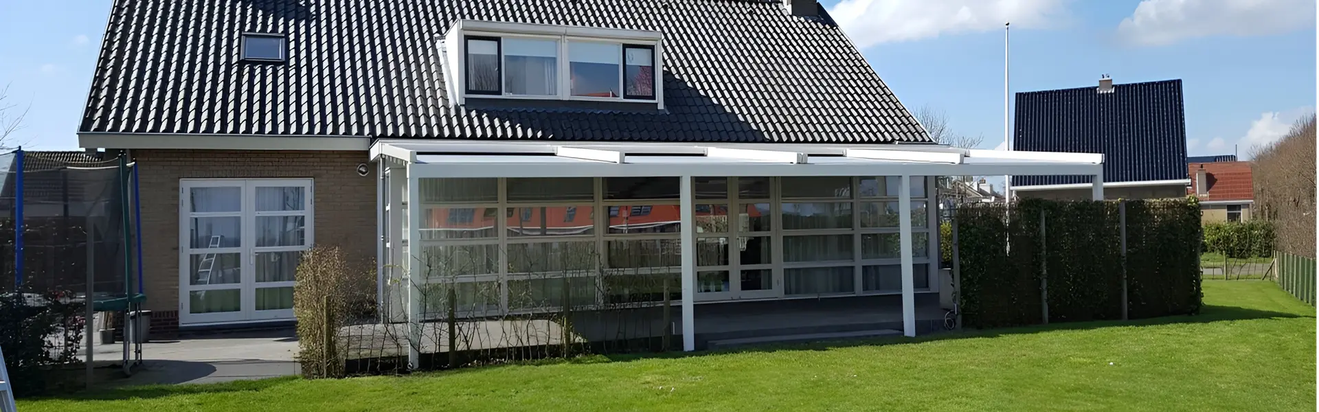 Witte overkapping met doek Pergotex aan een woning met ruime tuin