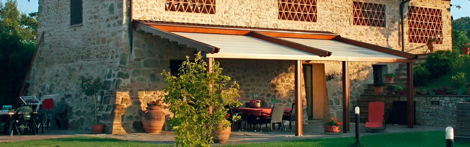 Woodplus houten vouwdak bij stenen huis met terras in tuin