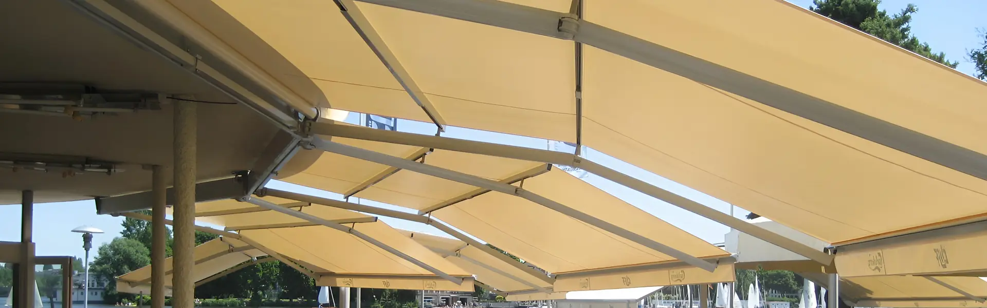 Zon en regenwering Sunrain met beige doeken en aluminium frames boven terras