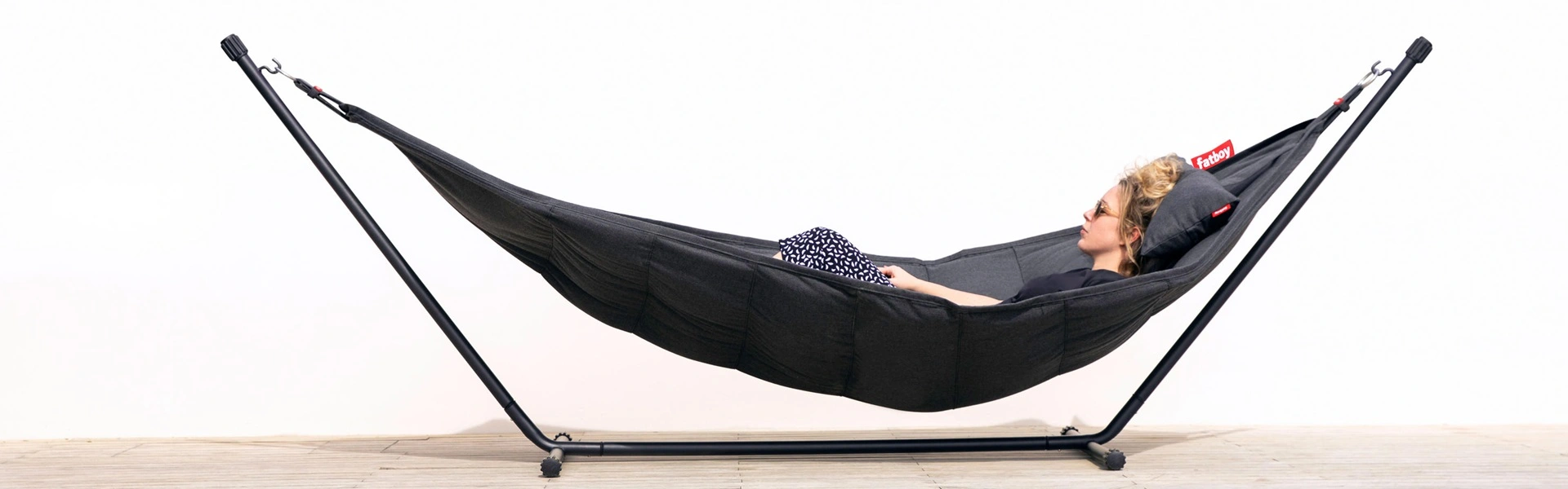 Zwarte Fatboy hangmat met Sunbrella stof en een persoon die ontspant