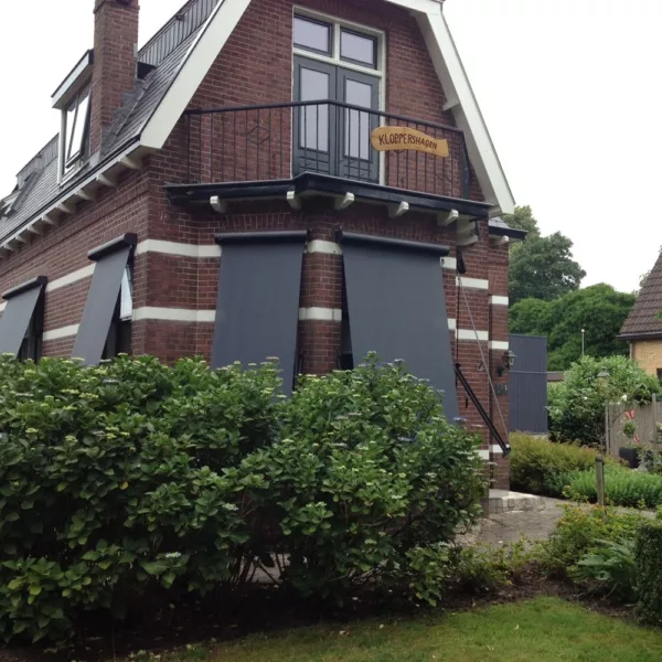 Donkere uitvalschermen US701 gemonteerd op een klassieke woning