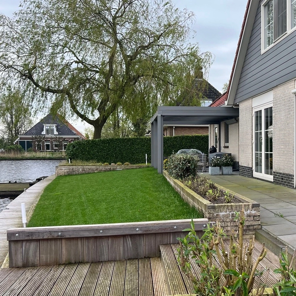 Glazen overkapping aan een woning met tuin en water in Nes