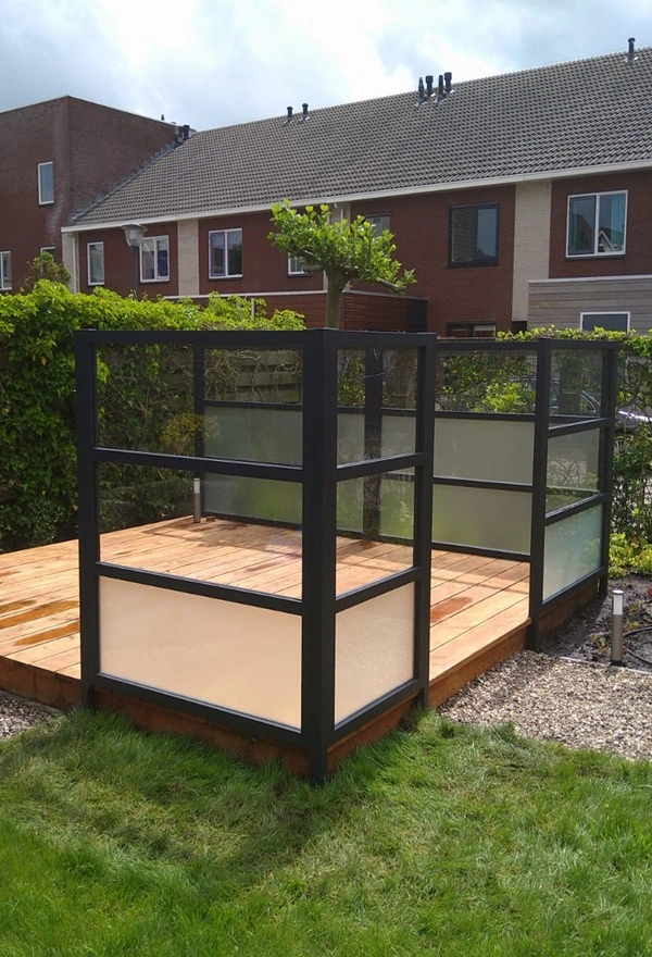 Glazen windscherm op houten terras in Leeuwarden door Veldman Zonwering, beschermt tegen wind