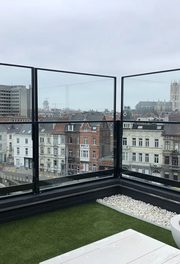 Glazen windschermen op dakterras met uitzicht over stad en extra comfort