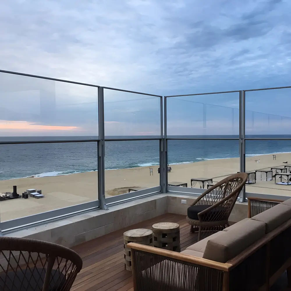 Glazen windschermen op terras in Griekenland met uitzicht op zee en zonsondergang Glazen windschermen op terras in Griekenland met uitzicht op zee en zonsondergang