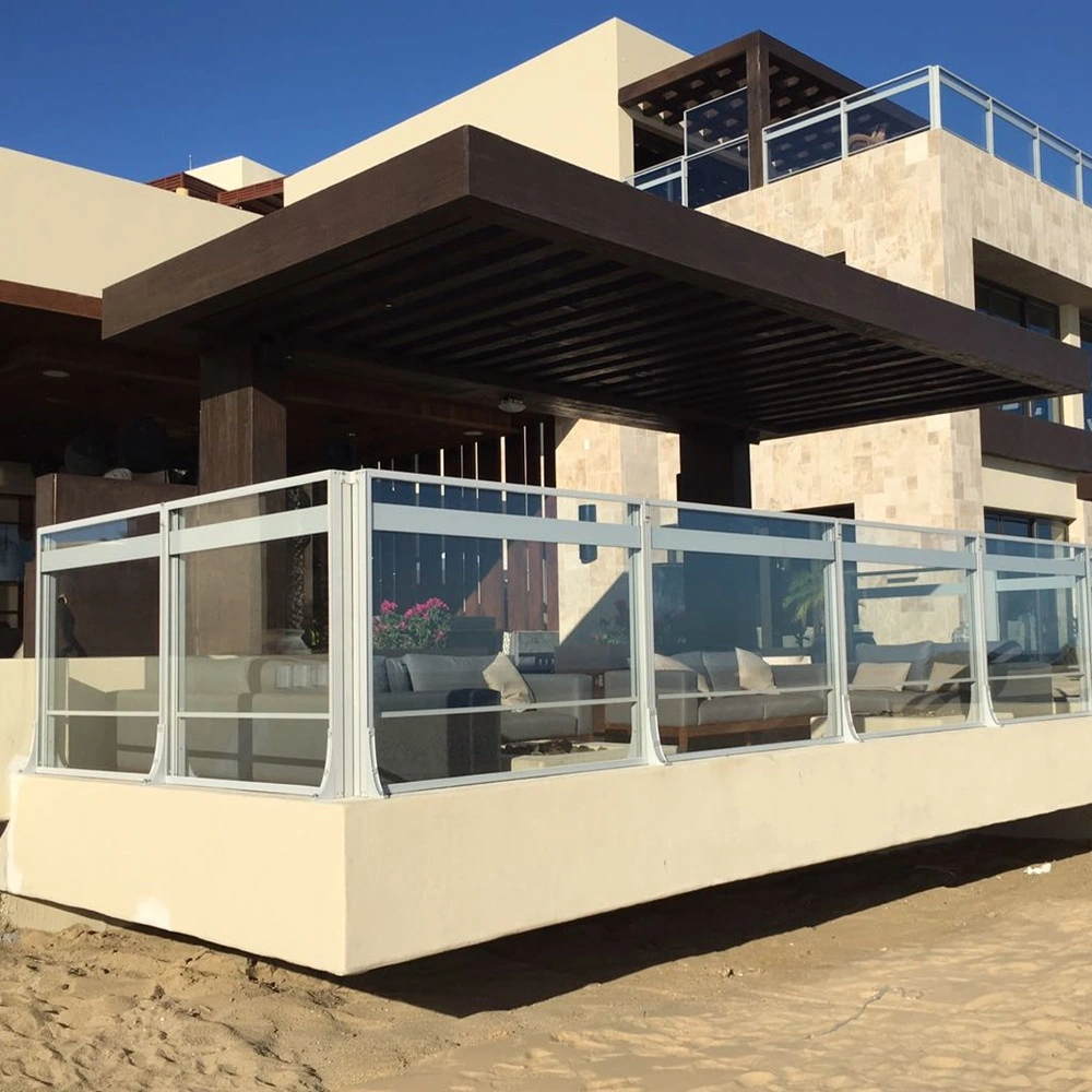 Glazen windschermen op terras in Spanje bieden beschutting tegen wind en zon Glazen windschermen op terras in Spanje bieden beschutting tegen wind en zon