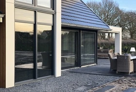Moderne woning met buitenjaloezieen en ruime glazen gevel