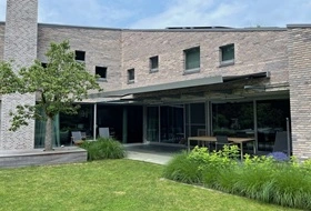 Moderne woning met glazen schuifpui en breed knikarmscherm