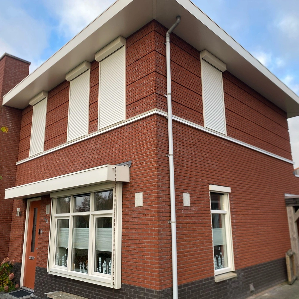 Rolluiken bij woning met rode bakstenen Rolluiken bij woning met rode bakstenen