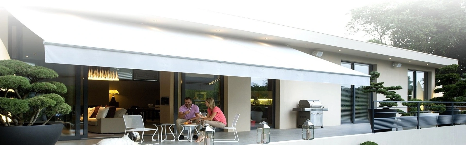 Stijlvolle elektrische zonwering boven een terras met loungehoek