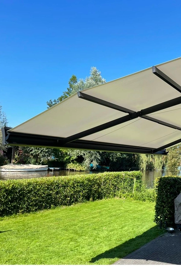 Uitklapbaar zon- en regenscherm bij tuin in Broek door Veldman Zonwering, weerbestendig Uitklapbaar zon- en regenscherm bij tuin in Broek door Veldman Zonwering, weerbestendig