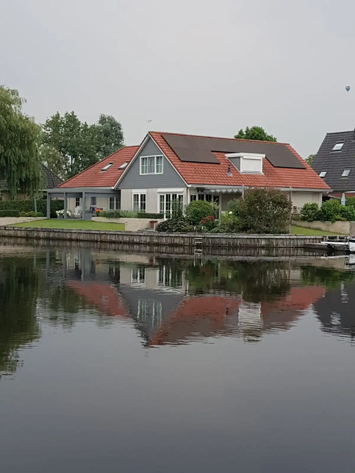 Woning met glazen overkapping gerealiseerd door Veldman Zonwering in Nes