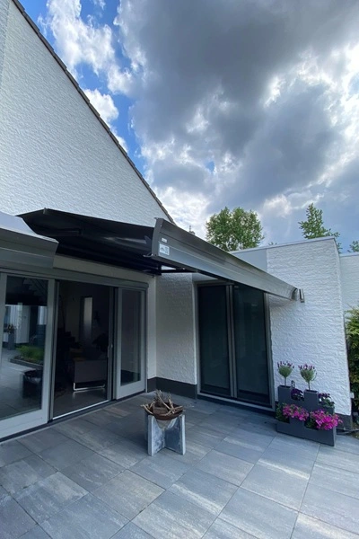 Zon en regenscherm Casa Sunrain bij een moderne woning Zon en regenscherm Casa Sunrain bij een moderne woning