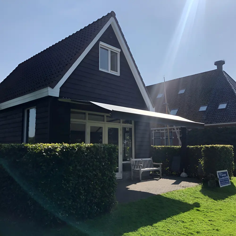 Zon- en regenscherm aan landelijk huis in Broek, geplaatst door Veldman Zonwering Zon- en regenscherm aan landelijk huis in Broek
