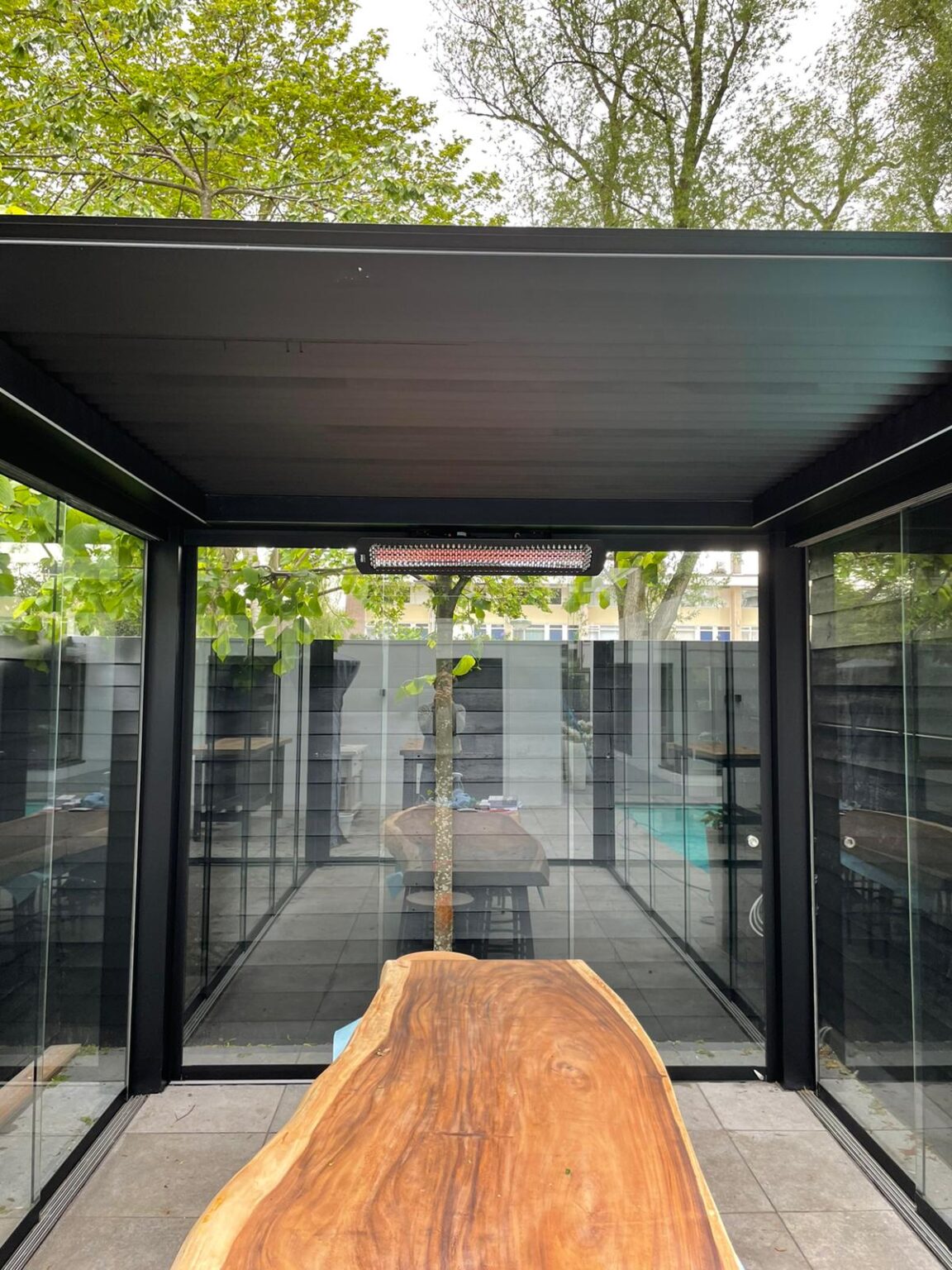 Harol terrasoverkapping met glazen wanden en houten eettafel in Amsterdam