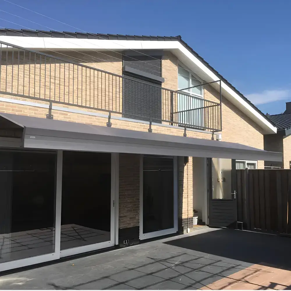Grijs zon en regenscherm aan moderne woning in Urk door Veldman Zonwering