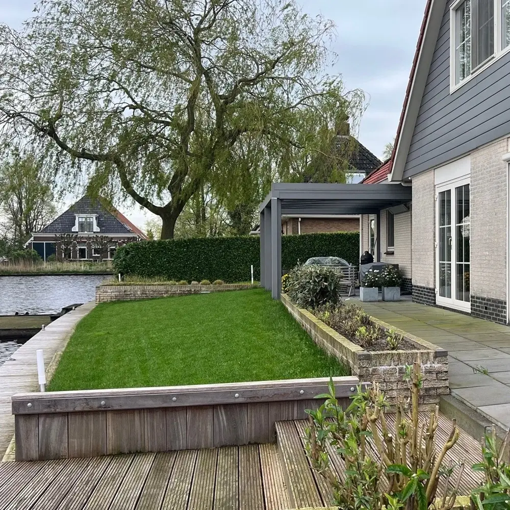 Glazen overkapping aan een woning met tuin en water in Nes