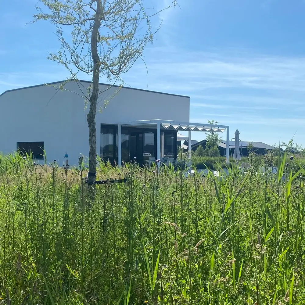 Veldman Zonwering terrasoverkapping met schuifdak in Blauwestad met groene omgeving