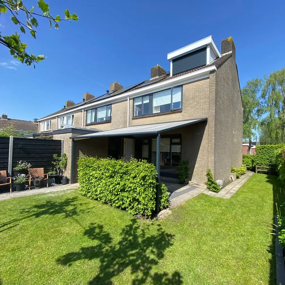 Veldman Zonwering textieloverkapping boven terras in groene achtertuin